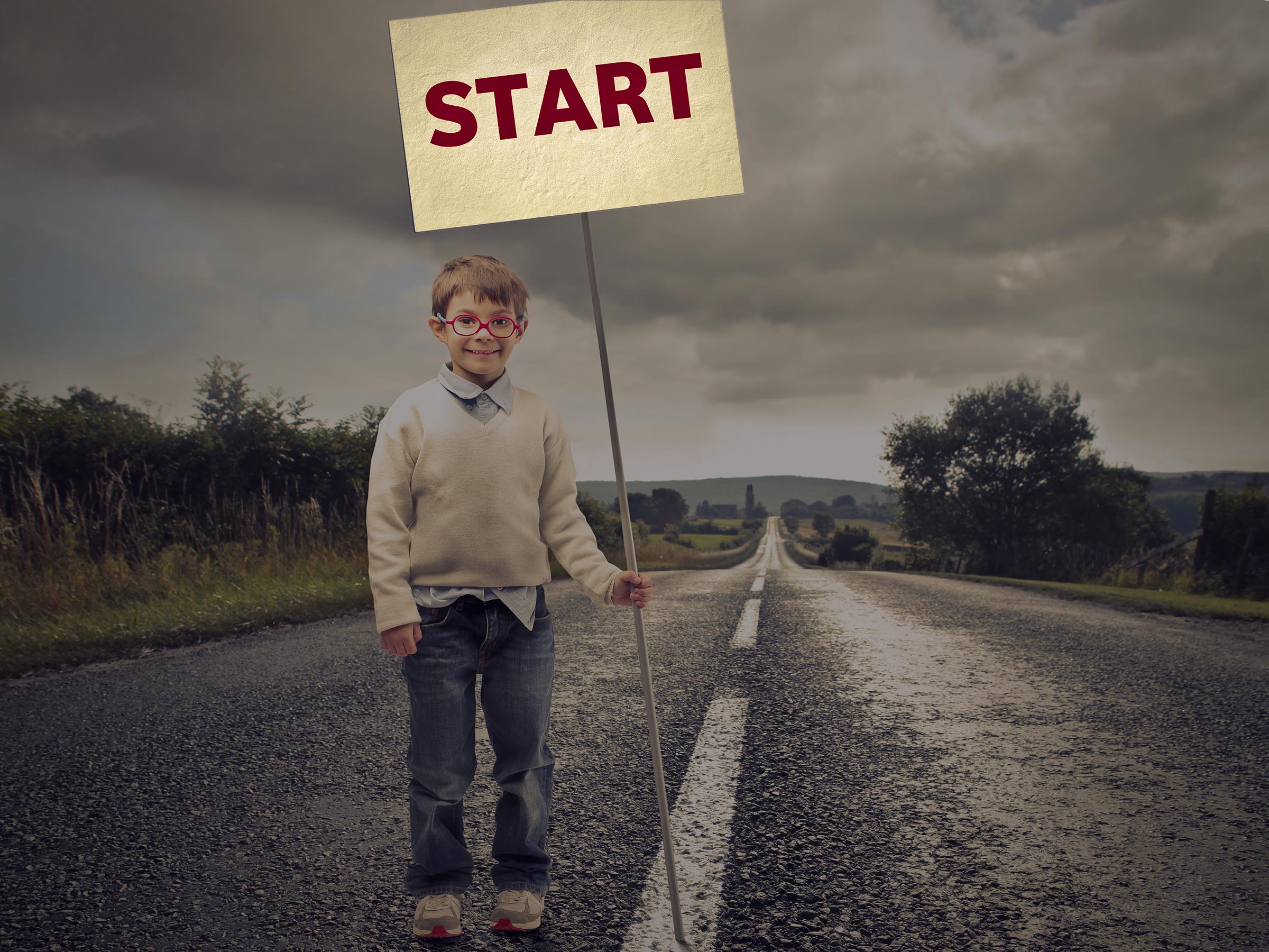 Picture of a child holding a sign that says Start